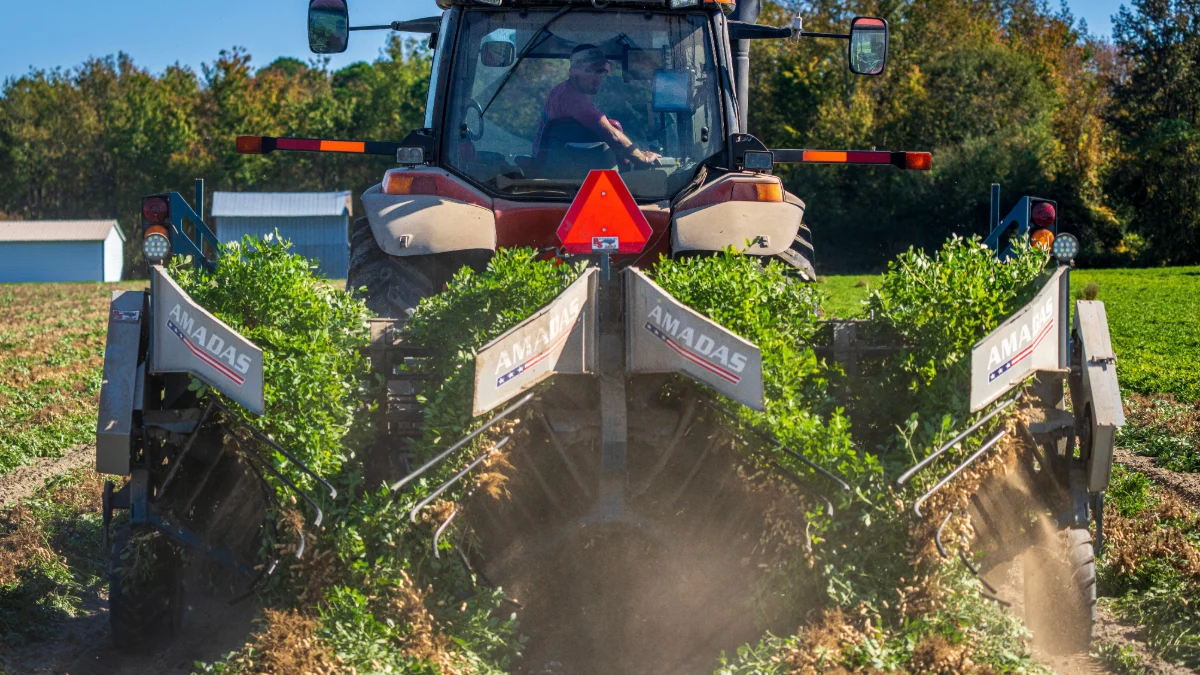 Rolnik obsługuje traktor, aby zaorać wiejskie pole, uchwycając życie rolnicze