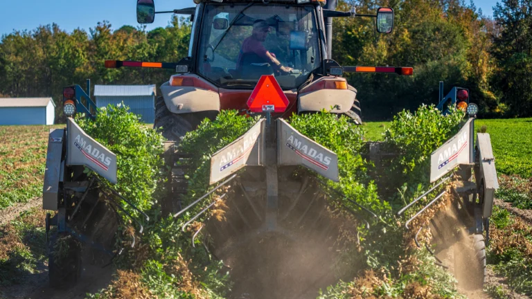 Rolnik obsługuje traktor, aby zaorać wiejskie pole, uchwycając życie rolnicze