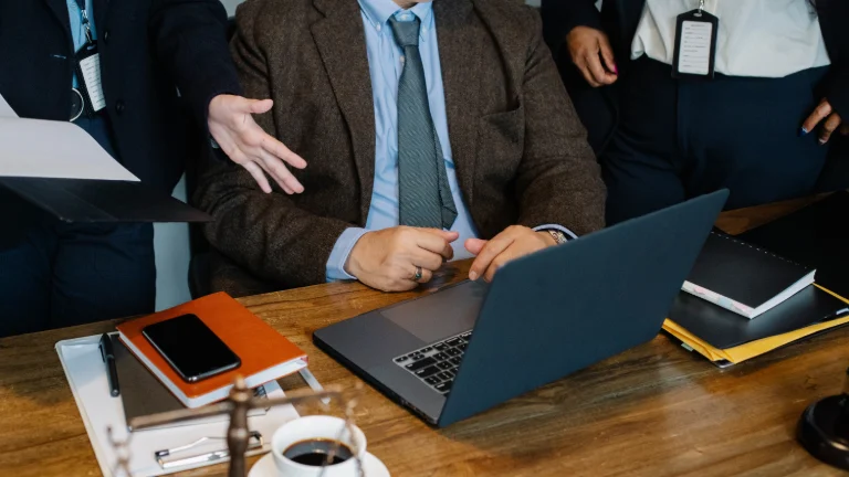 Profesjonaliści ogrodnicy omawiają strategie wynagradzania w pracy na spotkaniu z laptopami i dokumentami na biurku