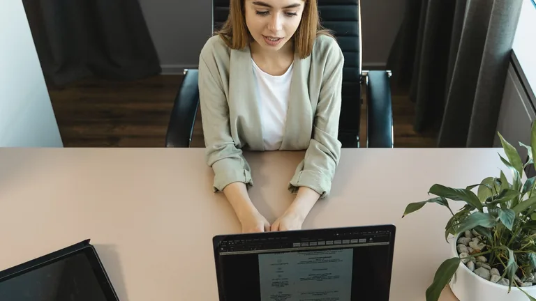Kandydat rozmawiający z rekruterem przy biurku podczas rozmowy kwalifikacyjnej